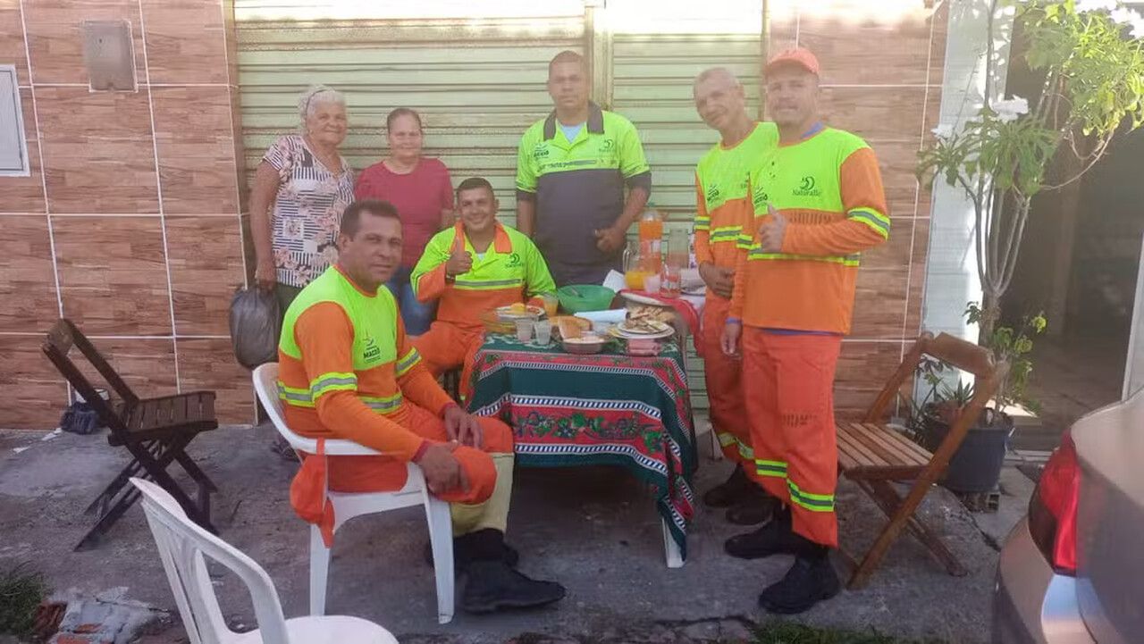 Moradoras preparam café da manhã natalino para garis que recolhem o lixo na rua onde moram, em Maceió